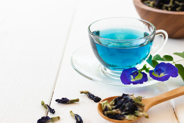 Cup of Butterfly pea flower tea on white wooden background. Health drink concept.