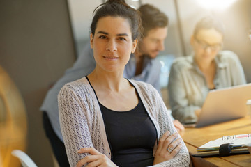 Focus on attractive brunette looking at camera in co working space