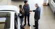 © Minerva Studio - Car dealer giving a handshake to a young couple