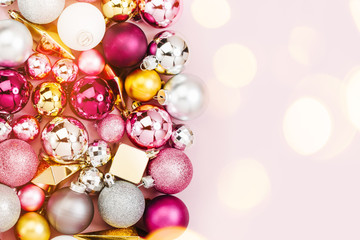 Holiday  arrangement with Stylish Christmas shiny baubles and gold crystals on pastel pink background. Flat lay, top view