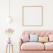 © marina_dikh - Poster mockup with square frame on empty wall in living room interior with pink sofa, multi-colored pastel pillows and hanging lamp. 3D rendering.
