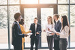 © sofiko14 - Business Corporate People Working Concept. Group of six young business people at the work meeting, holding financial reports and documents. Teamwork