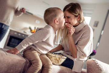 Wall Mural - Smiling family eating popcorn at home