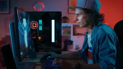Wall Mural - Professional Gamer Playing First-Person Shooter Online Video Game on His Powerful Personal Computer with Colorful Neon Led Lights. Young Man is Wearing a Cap. Living Room Lit with Warm Soft Light.
