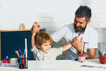 Happy family. The boy and his father are playing in the children room. Funny homework to prepare for school. Preschooler and his father enjoy the day. Bearded father and cute son