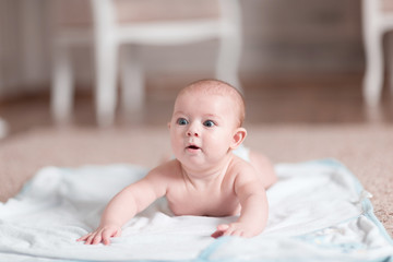 pretty baby learns to crawl on the bed .