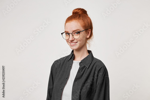 A Young Red Haired Girl Stands In A Half Turn Looking At The