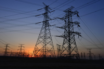 The silhouette of the evening electricity transmission pylon