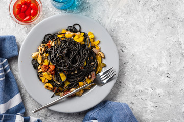 Wall Mural - Black pasta with seafood, anchovies, tomatoes and bell peppers.