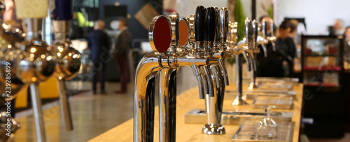 beer taps lined up on the counter of a pub