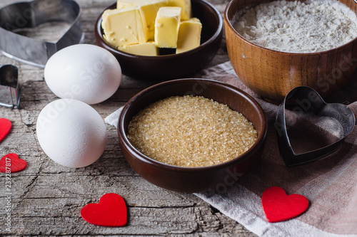 Zdjęcie XXL Składniki do pieczenia dla Valentine Cookies - mąka, cukier, masło, wałkiem, jaja i kształt serca na drewnianym stole rustykalnym kuchni. Cloise-up