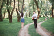 © soleg - young couple walking in the forest and playing guitar, summer nature, bright sunlight, shadows and green leaves, romantic feelings