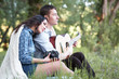 © soleg - young couple sitting in the forest and playing guitar, summer nature, bright sunlight, shadows and green leaves, romantic feelings