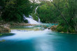 A small waterfall with turquoise water in Plitvice Lakes National Park in Croatia.