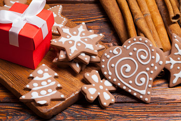 Sticker - Red gift box and decorated gingerbread Christmas cookies on wooden table