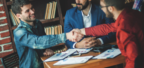 business partners shake hands after discussing the contract at t