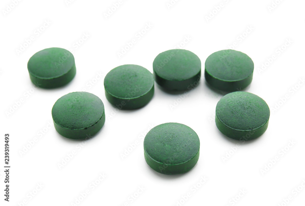 Spirulina tablets on white background