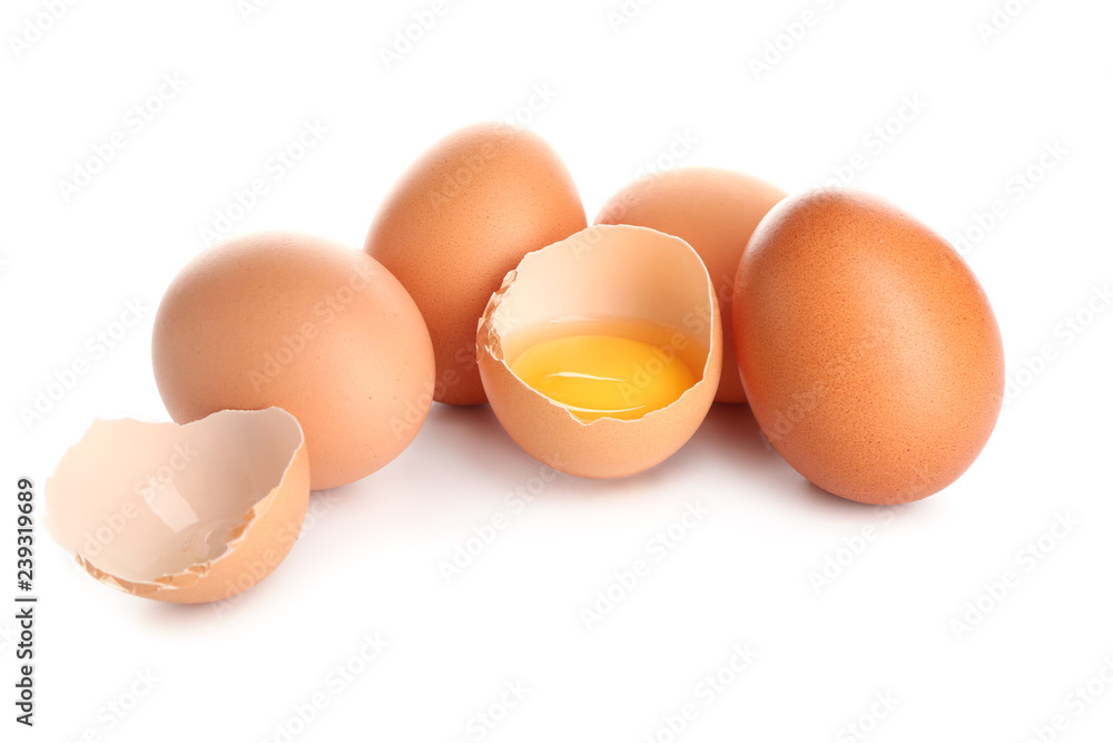 Cracked and whole chicken eggs on white background