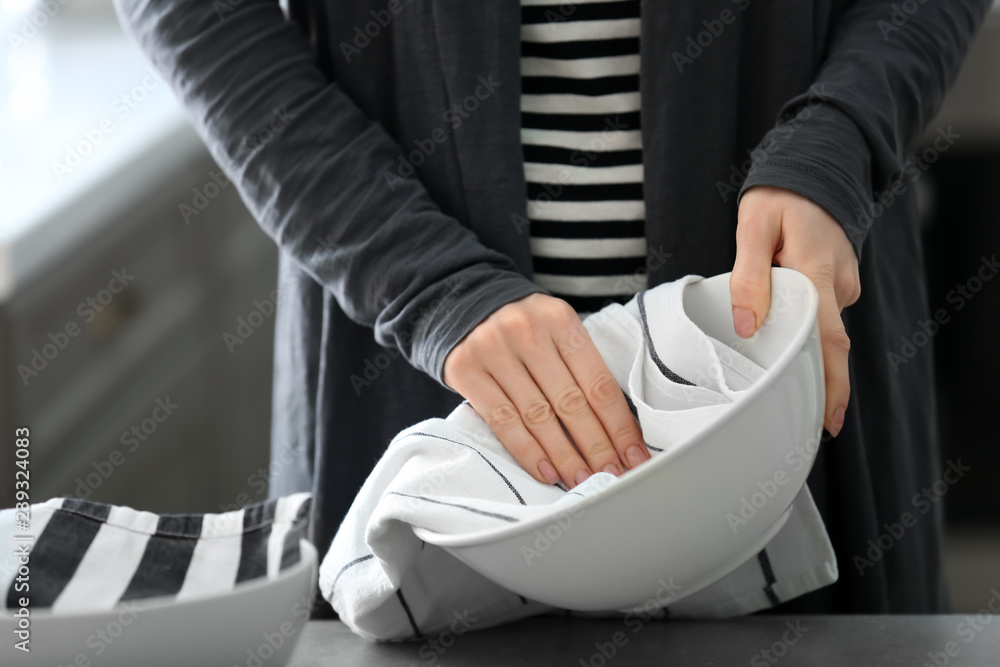 Woman wiping plate with kitchen towel