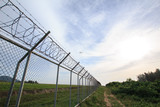 Fototapeta  - Chain link fence with grass field Phuket International Airport