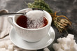 © Pixel-Shot - Adding of sugar to cup with aromatic tea on grey table