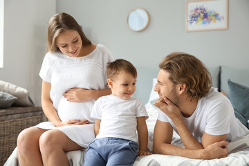 Wall Mural - Young pregnant woman with her family in bedroom