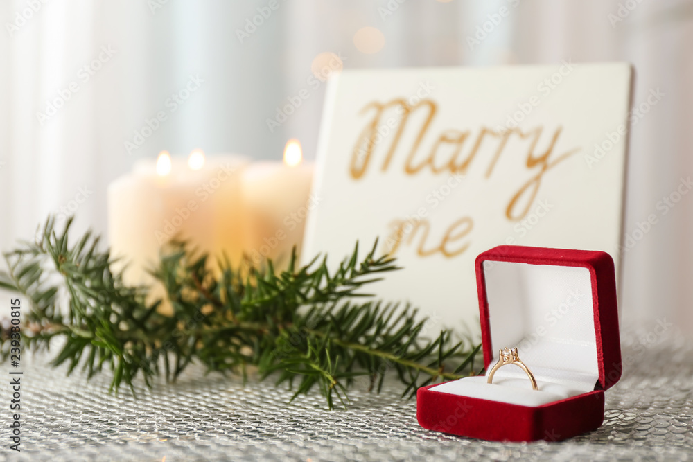 Box with beautiful engagement ring on table
