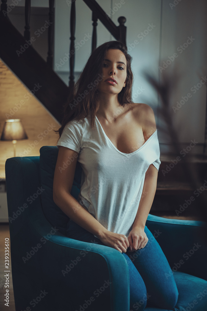 Sexy girl sitting on a chair in a living room Stock Photo | Adobe Stock