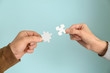 © Pixel-Shot - Male and female hands with pieces of puzzle on color background