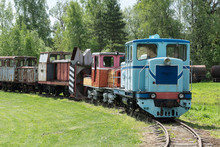 Old Train And Locomotive. Railroad Tracks Stretches And Green Grass And Trees. Railway Road Environment Background.