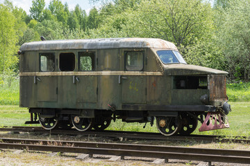 Old train and locomotive. Railroad tracks stretches and green grass and trees. Railway road environment background.