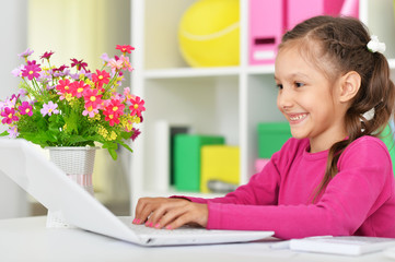 Poster - Portrait of cute emotional girl using laptop at home