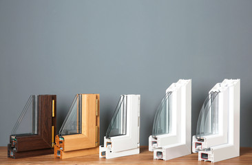 Wall Mural - Samples of modern window profiles on table against gray wall. Installation service