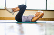 © Erickson Stock - Mature adult woman doing crunches at a gym.