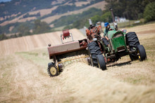 Tractor Creating Hay Bales In Field