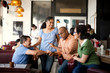 © Erickson Stock - Smiling friends meeting for coffee at a local diner.