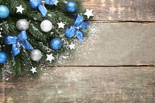 Foto Christmas fir tree branches with decorations on grey wooden table