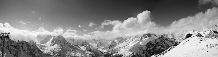 Black and white panorama of ski slope and snowy mountains