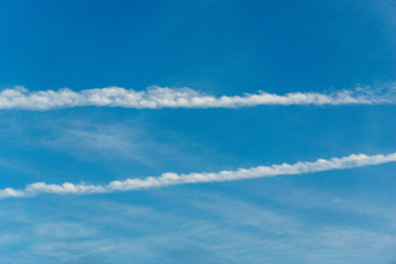 Wall Mural - blue sky with line-shaped clouds - contrails of a plane or chemtrails