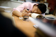 © Erickson Stock - Stamp being held by a young adult who is asleep on a table.