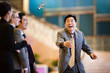 © Erickson Stock - Mid-adult businessman laughing with colleagues in a lobby.