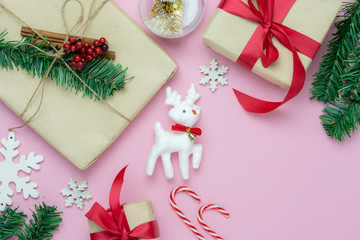 Wall Mural - Table top view of Merry Christmas decorations & Happy new year ornaments concept.Flat lay essential objects the reindeer & gift box on modern rustic pink paper background at home studio office desk.