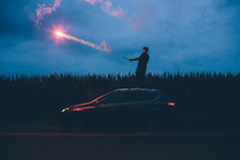A Man Shoots Fireworks Off Of The Roof Of His SUV Car In A Corn Field