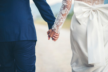 Close up of married couple holding hands in wedding day