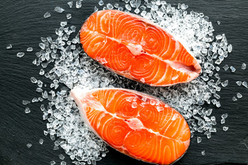 Wall Mural - Raw salmon fish on black plates for cooking steaks. Restaurant kitchen background top view