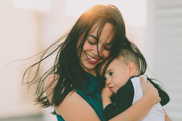 a mother comforting her son as the wind blows in her hair.