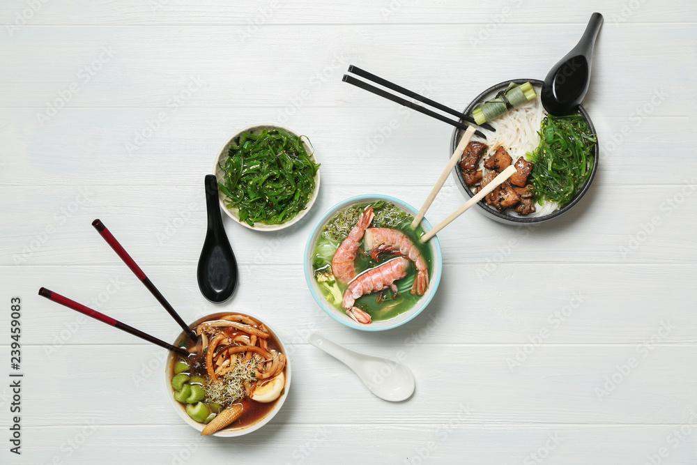 Assortment of tasty Chinese soups on white table