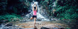 Young woman practice yoga near waterfall in forest