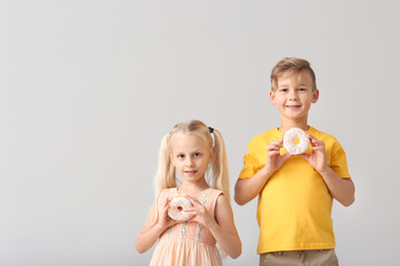 Canvas Print - Cute little children with donuts on light background