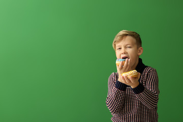 Sticker - Cute little boy with donuts on color background